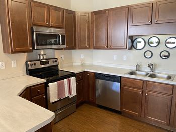 a kitchen with wooden cabinets and stainless steel appliances